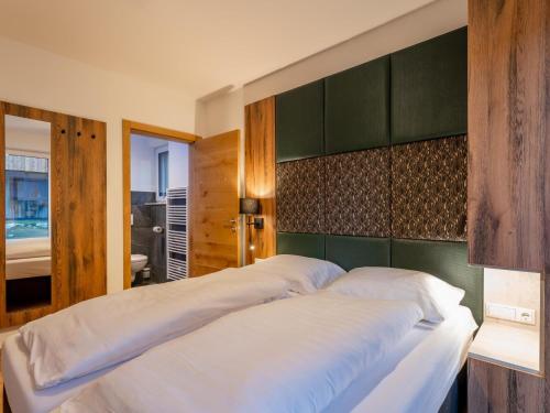 a bedroom with a large bed with a green headboard at Mountain Chalet Krek Wak Wou in Sankt Lorenzen ob Murau