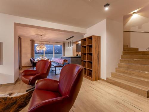 a living room with chairs and a table and stairs at Mountain Chalet Krek Wak Wou in Sankt Lorenzen ob Murau