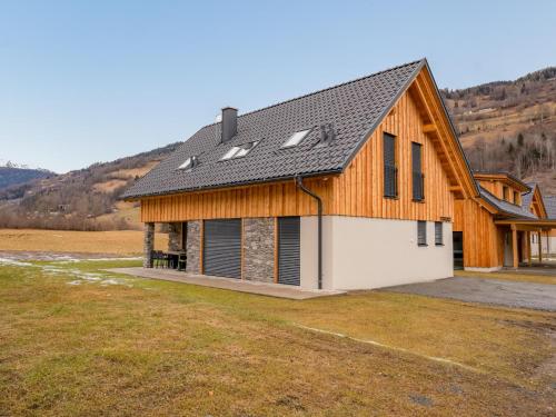 a house with a gambrel roof with a garage at Mountain Chalet Krek Wak Wou in Sankt Lorenzen ob Murau