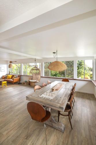 a living room with a large wooden table and chairs at Lihau Boho House in Kailua-Kona
