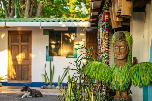 a statue of a face sitting in front of a house at Olas Permanentes El Zonte in El Zonte