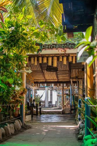 a building with a covered walkway with trees and plants at Olas Permanentes El Zonte in El Zonte