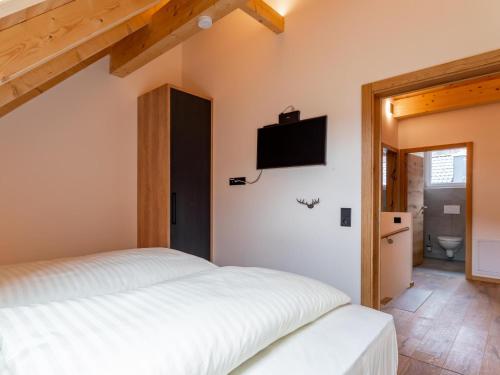 a bedroom with a bed and a tv on the wall at Bergzicht 2A in Sankt Lorenzen ob Murau