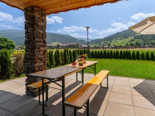 a table and bench on a patio with a view of a vineyard at Bergzicht 2A in Sankt Lorenzen ob Murau