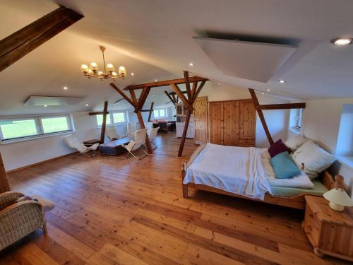 a bedroom with a large bed in a room with wooden floors at Pugholz XL in Hasselberg