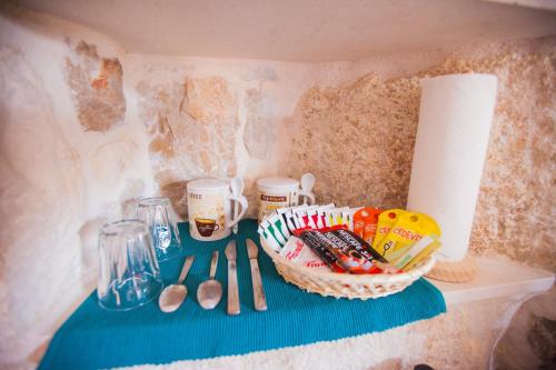 a shelf with a bowl of candy and a basket of utensils at Golden Gate Dream Rooms in Split