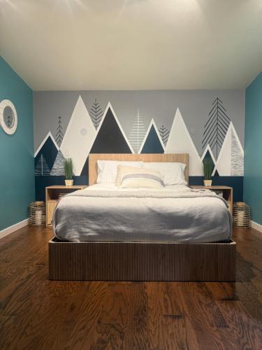 a bedroom with a bed and a wall with mountains at 420 LOFT in Glenwood Springs