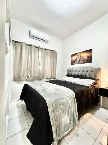 a bedroom with a large bed and a window at APARTAMENTO CONFORT NO CENTRO Ar cond 2 QUARTOS in Formosa