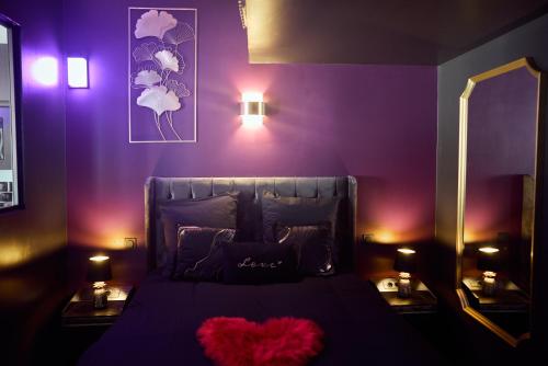 a purple bedroom with a bed with a heart pillow at Romance House in Arnouville-lès-Gonesse