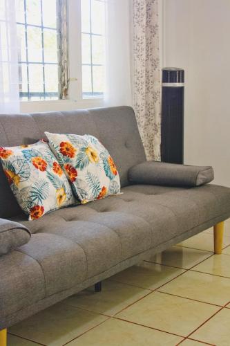a couch with two pillows on it in a living room at Casa Emma Quepos in Quepos