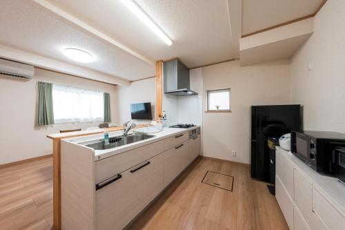 a kitchen with a sink and a refrigerator at AOMORI HORIZON 5 minutes walk from Tsutsui Station 筒井 in Aomori