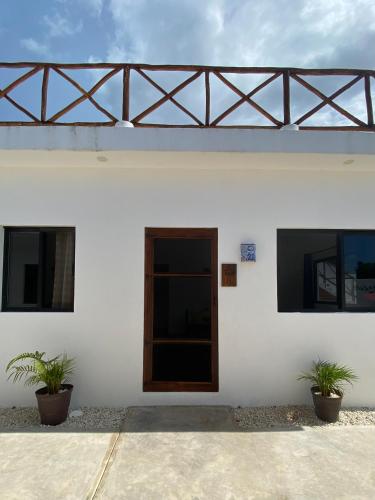 a white building with two potted plants on it at Casa Loto B in Chelem