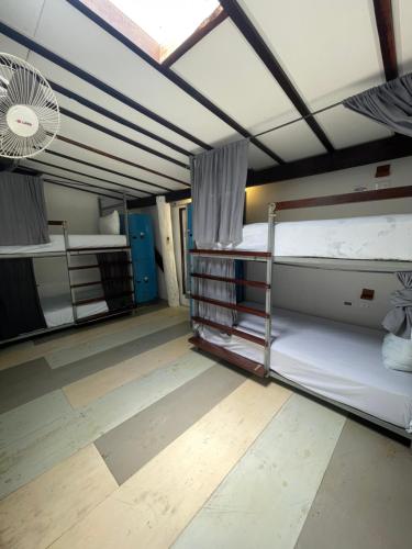 a room with two bunk beds and a fan at The Yak Lake House - Hostal Bacalar in Bacalar