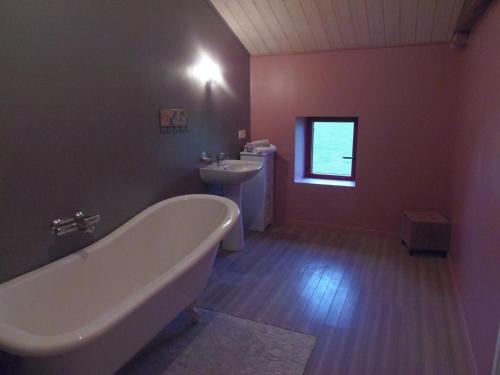 a bathroom with a bath tub and a sink at Gîte familial avec jardin clos à Falleron - FR-1-426-458 in Falleron