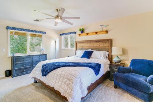a bedroom with a bed and a blue chair at Lovely Riverfront Grants Pass Home Pool and Hot Tub in Grants Pass
