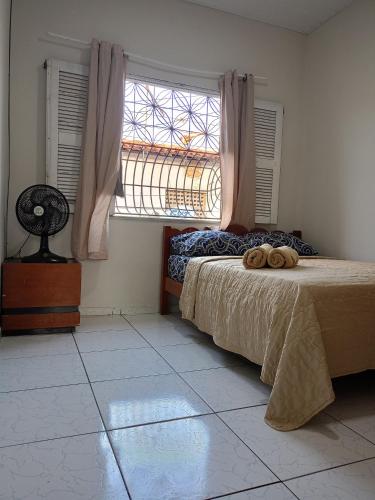 a bedroom with a bed and a large window at Cozy and fast Wi-Fi 15 minutes from the sea in Caucaia