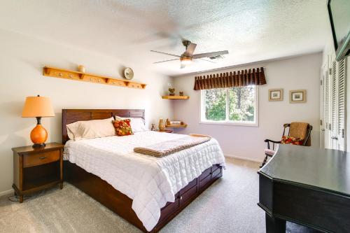 a bedroom with a bed and a desk and a window at Lovely Riverfront Grants Pass Home Pool and Hot Tub in Grants Pass