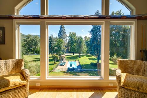 a large window in a living room with a view of a pool at Lovely Riverfront Grants Pass Home Pool and Hot Tub in Grants Pass