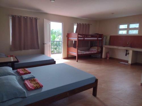1 Schlafzimmer mit 2 Etagenbetten und einem Balkon in der Unterkunft Suki Beach Resort "3-3" Family Aircon Room in Sorsogon