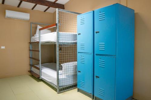 a room with blue lockers and bunk beds at The Yak Lake House - Hostal Bacalar in Bacalar