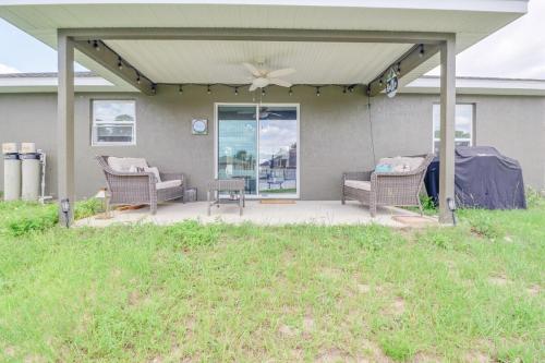 a patio with two chairs and a ceiling fan at COZY home with fenced patio in Ocala
