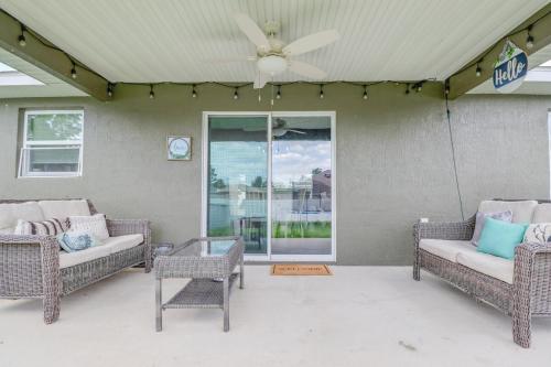 a porch with wicker chairs and a ceiling fan at COZY home with fenced patio in Ocala