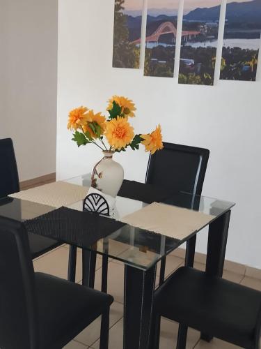 a dining room table with a vase with flowers in it at Alquiler de apartamento por días in Panama City