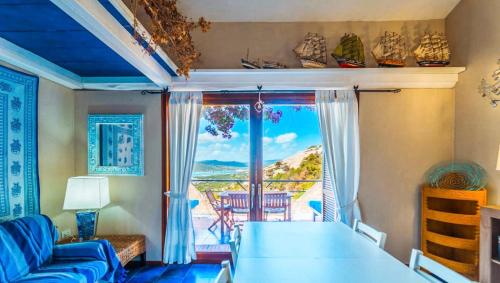a living room with a blue couch and a large window at Le Terrazze di Porto Rotondo - Vista Mare in Porto Rotondo