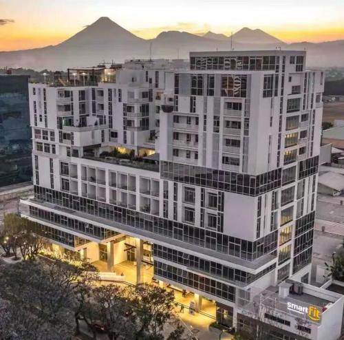 a large white building with a sunset in the background at Apartamento comodo cerca del aeropuerto in Estación Pamplona