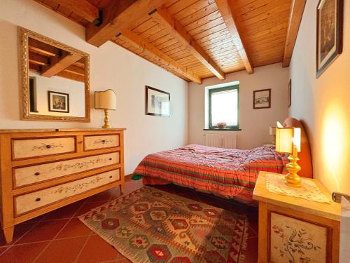 Un dormitorio con una cama, una cómoda y un espejo. en Rifugio Di Luce con 3 Camere, Garage e fermata Skibus - a 3 minuti dalle piste, en Temù