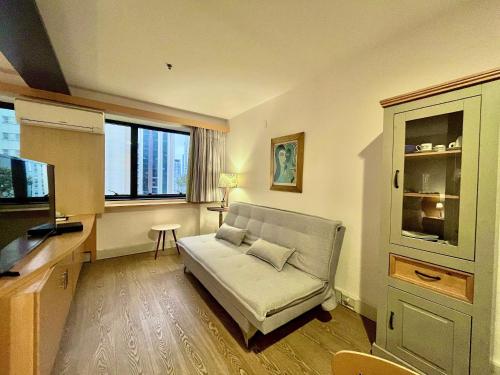 a living room with a couch and a television at LFlats Hotel Alameda Lorena Jardins in Sao Paulo