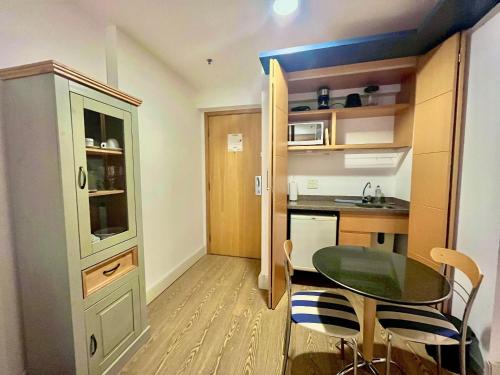 a small apartment with a table and a kitchen at LFlats Hotel Alameda Lorena Jardins in Sao Paulo