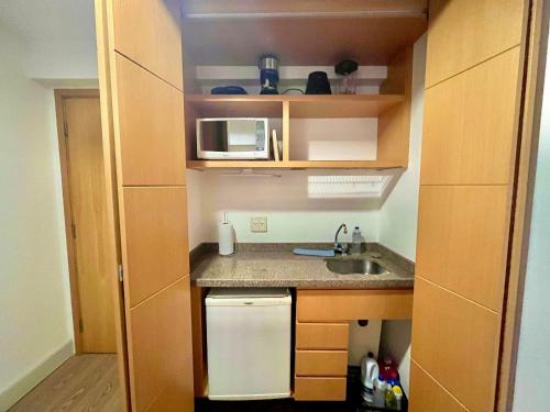 a small kitchen with a sink and a microwave at LFlats Hotel Alameda Lorena Jardins in Sao Paulo