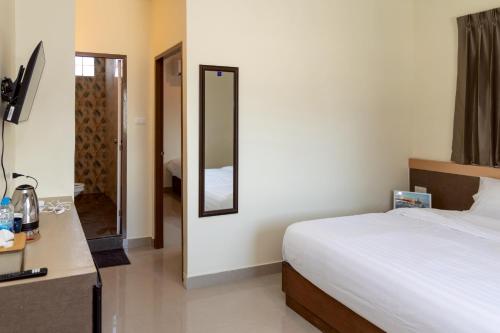 a hotel room with a bed and a mirror at Sea Inn Pattaya in Pattaya Central