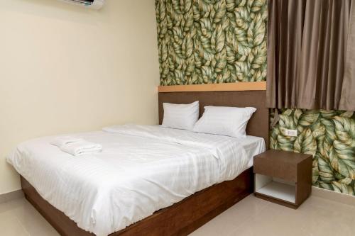 a bedroom with a bed with a painting on the wall at Sea Inn Pattaya in Pattaya Central