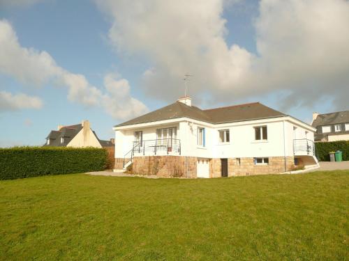 a white house on top of a grass field at Holiday Home in Brittany with Sea View in Lampaul-Plouarzel
