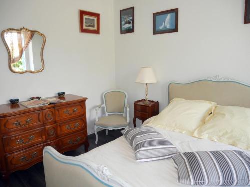 a bedroom with a bed and a dresser and a mirror at Holiday Home in Brittany with Sea View in Lampaul-Plouarzel