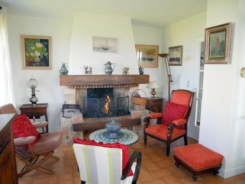 a living room with a fireplace with chairs and a table at Holiday Home in Brittany with Sea View in Lampaul-Plouarzel