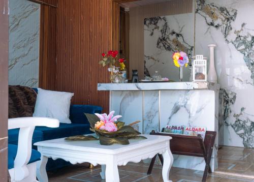 a living room with a couch and a table with flowers on it at Pequeño apartamento en área de fácil acceso in San Felipe de Puerto Plata
