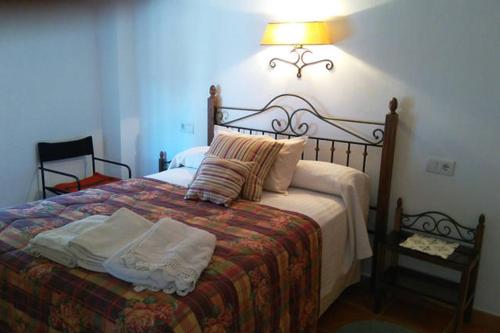 una camera da letto con un letto con una lampada sopra di Un balcón al Guadalquivir a Hornos