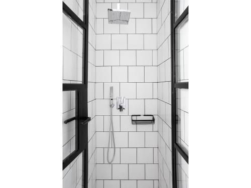 アテネにあるAthens View Loft - 04の白いタイル張りのバスルーム(シャワー付)