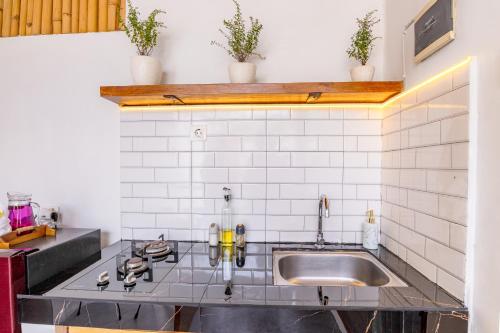 cocina con fregadero y azulejos blancos en Kiki Village Private Villas, en Canggu