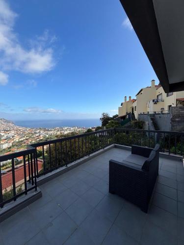 a balcony with a bench and a view of a city at Casa Barcelos in Funchal