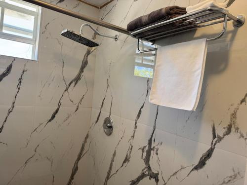 a bathroom with a marble shower with a towel at Dockside Studio in Providenciales, Turks and Caicos in Turtle Cove