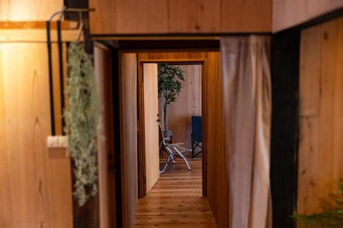 a hallway leading to a room with wood floors and a door at Guest House Henza in Henza