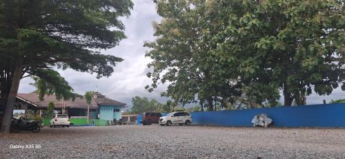 a group of cars parked next to a blue fence at SAHATI HOMESTAY PAYAKUMBUH & Swimingpool in Payakumbuh