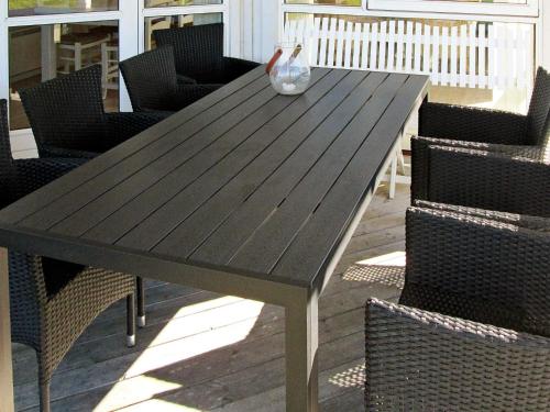 a wooden table with chairs and a vase on it at 5 person holiday home in Rude-By Traum in Rude
