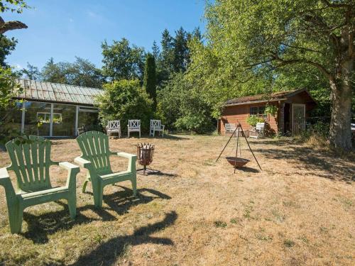 two green chairs sitting in a yard next to a building at 6 person holiday home in Brædstrup-By Traum in Brædstrup