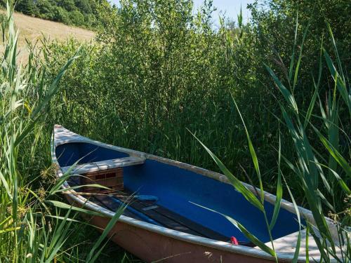 a blue boat sitting in some tall grass at 6 person holiday home in Brædstrup-By Traum in Brædstrup