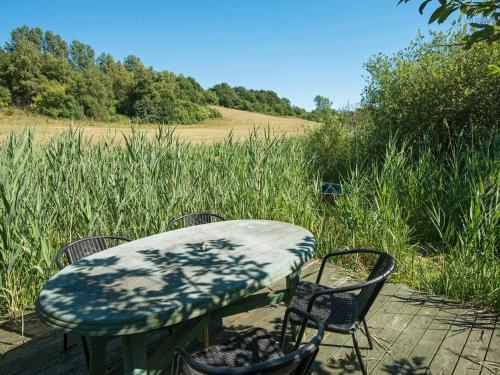 a table and chairs sitting on a wooden deck with a table and chairs at 6 person holiday home in Brædstrup-By Traum in Brædstrup